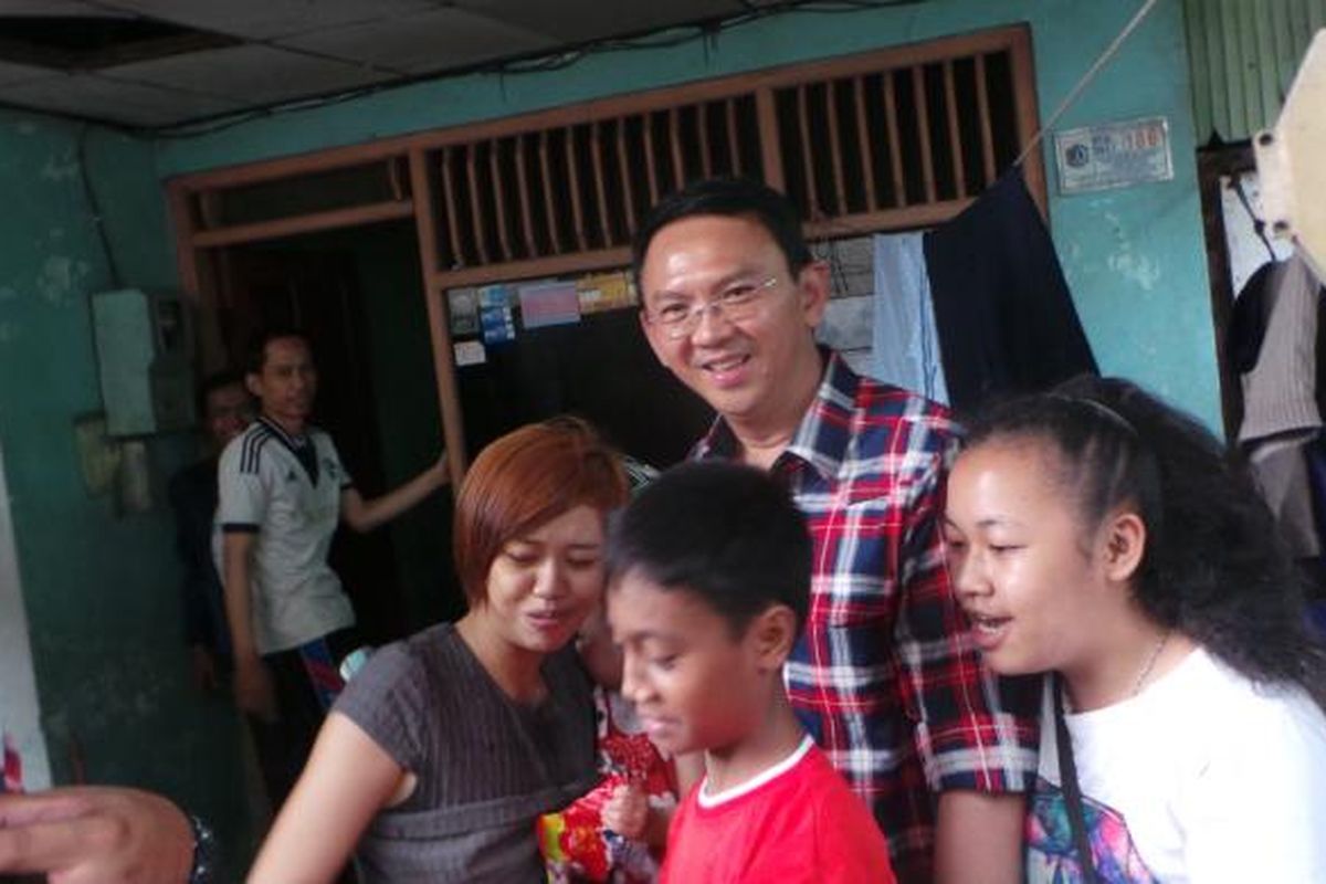 Calon gubernur nomor pemilihan dua DKI Jakarta Basuki Tjahaja Purnama atau Ahok saat berfoto bersama warga dan hujan deras mengguyur, di Jalan Peta Selatan, Kalideres, Jakarta Barat, Minggu (5/2/2017).