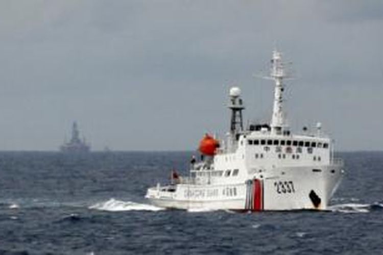 Kapal penjaga pantai China siaga di dekat anjungan minyak China di laut China Selatan yang terlihat di latar belakang