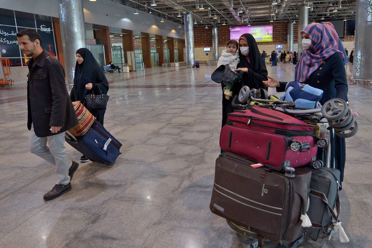 Warga negara Irak mengenakan masker saat tiba di bandara Internasional Najaf, Iran, 21 Februari 2020. Irak memberlakukan pemeriksaan ketat setelah Iran mengumumkan kasus penularan virus corona.