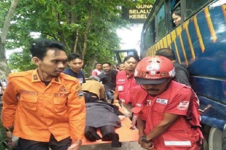 Sejumlah petugas membopong Arlin Darfah, seorang pemudik yang pingsan dalam bus di Simpang Padalarang, Kabupaten Bandung Barat, Jawa Barat, saat hendak mudik ke Garut.