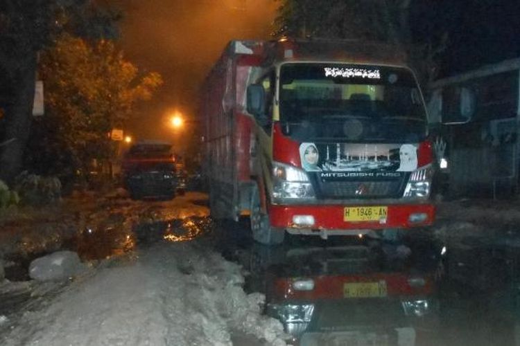 Puluhan kendaraan diparkirkan berbaris di tengah jalan utama Demak-Bonang, Rabu (26/3/2014) malam, sebagai bentuk protes atas lambannya penanganan Pemerintah Daerah Kabupaten Demak terhadap kerusakan jalan.