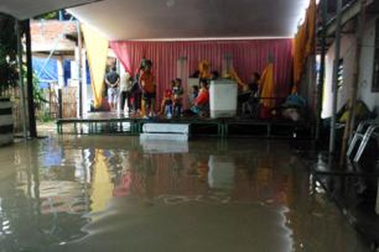Tenda yang sedianya tempat melaksanakan pesta pernikahan berubaha menjadi tempat mengungsi saat banjir melanda Kota Manado, Minggu (11/1/2015)