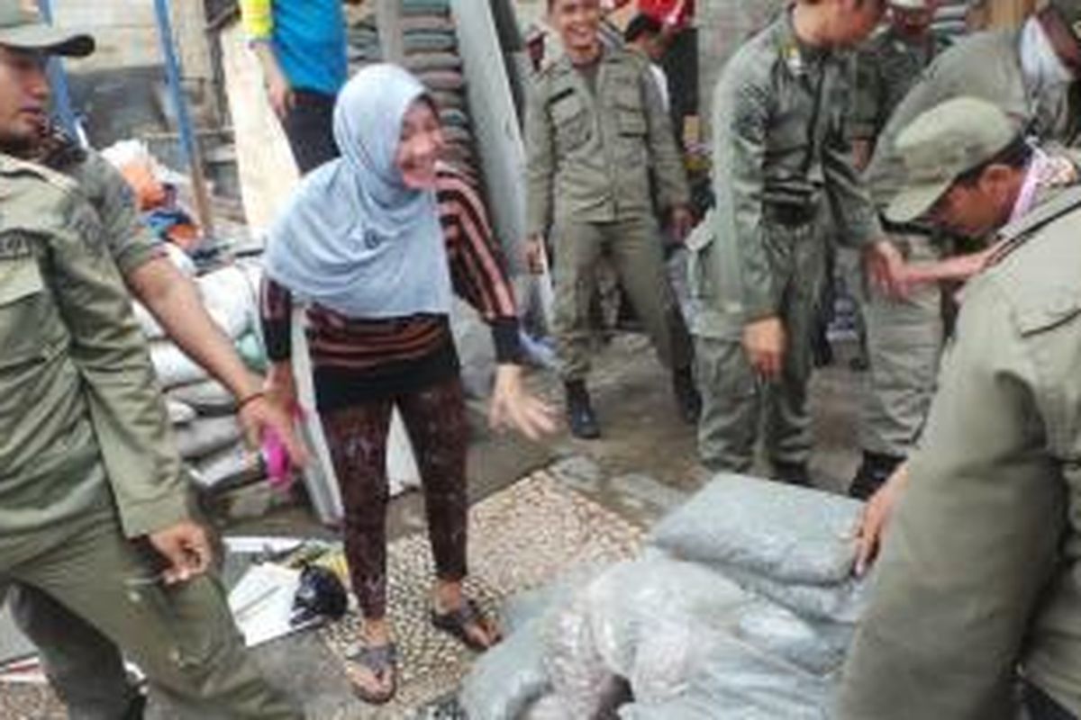 Tini (50), penjual batu alam mengomel saat penertiban di toko batu alam miliknya di Jalan DI Panjaitan, Cipinang Melayu, Makasar, Jakarta Timur. Penertiban terkait Proyek Tol Becakayu, Rabu (4/2/2015).