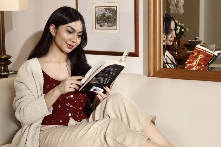 Gaya kasual Ariel Tatum pakai batik jumputan merah dan cardigan krem.