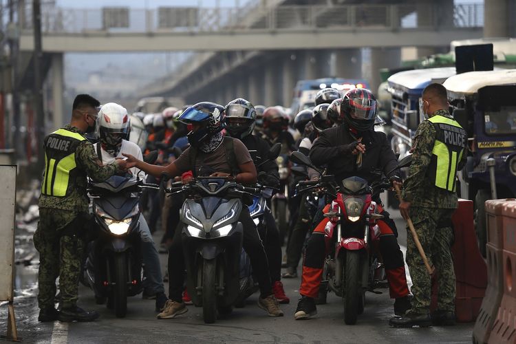Polisi memeriksa para pengendara motor di pos pemeriksaan, dalam rangka menerapkan pembatasan lebih ketat untuk menekan penyebaran Covid-19 di Marikina City, Filipina, Jumat (6/8/2021).