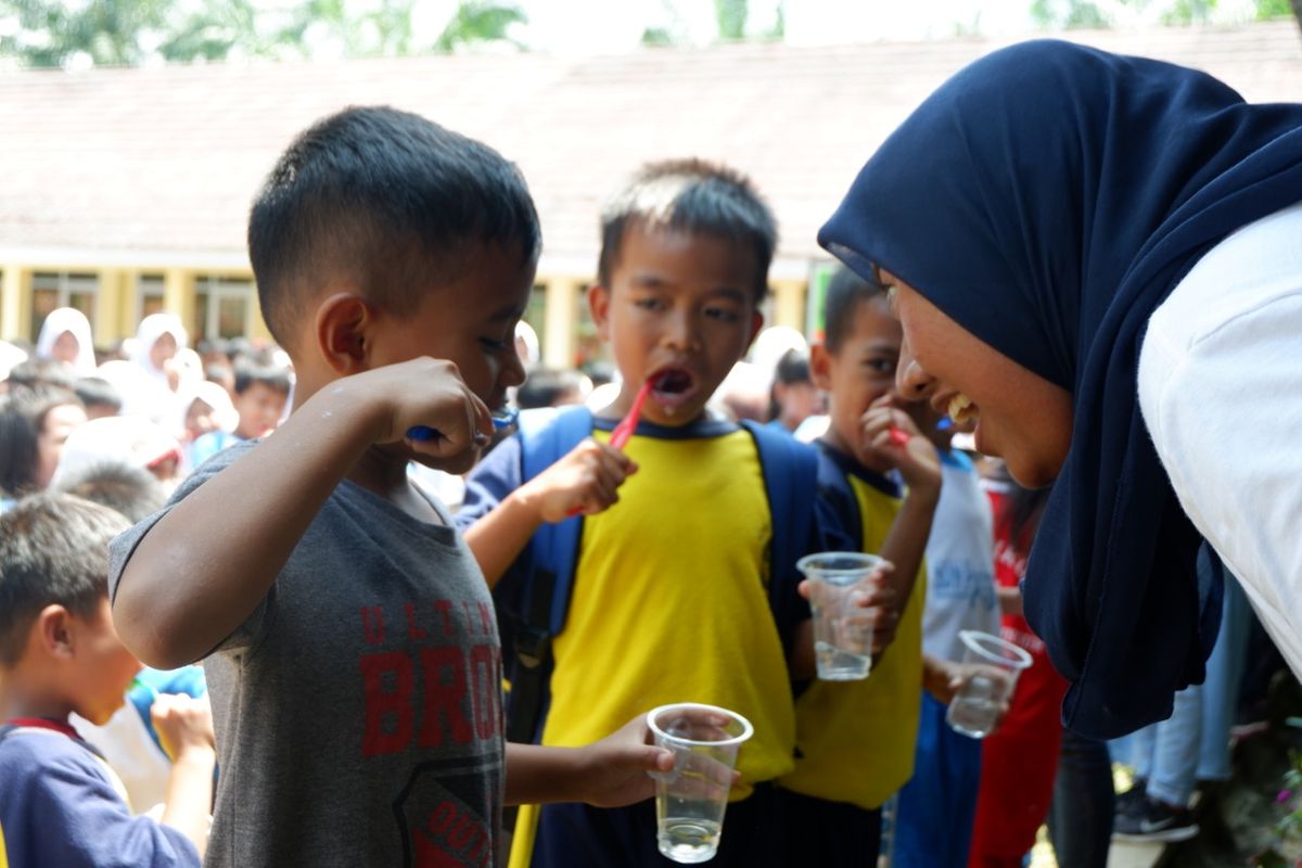 Seorang penerima beasiswa LPDP sedang mengajari anak menggosok gigi yang benar, di SD desa Cimulang, Bogor dalam program yang digelar APK ke-141 LPDP (30/3/2019).