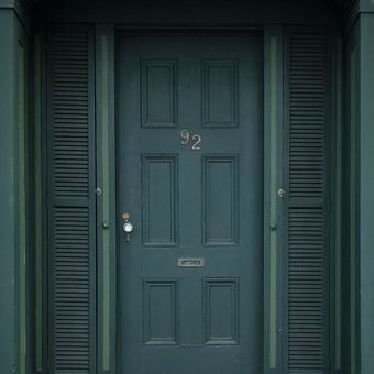 Ilustrasi pintu rumah berwarna hijau. 