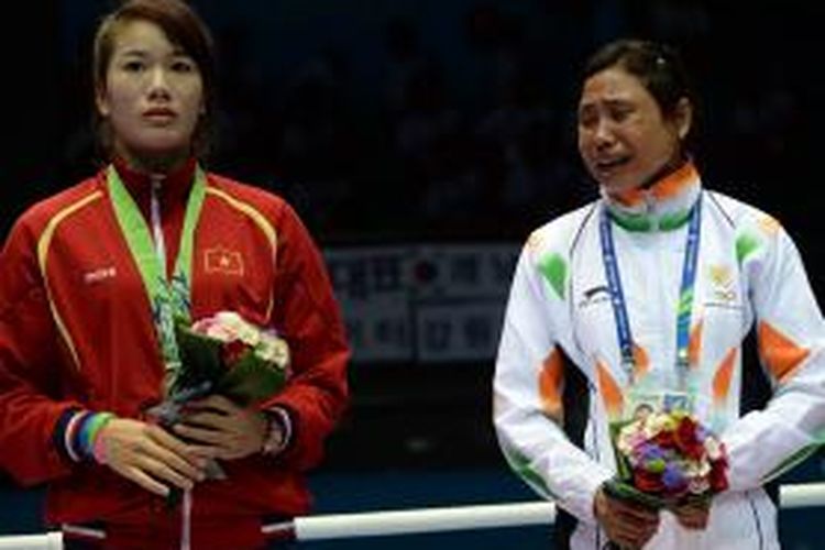 Sarita Devi (kanan) yang menangis di podium dan menolak mengenakan medali yang didapatkannya, Rabu (1/10/2014), sebagai protes atas penjurian yang menurut dia menyebabkan kekalahannya di babak semifinal tinju putri Asian Games 2014. 