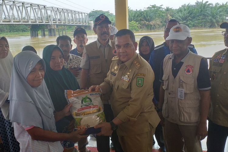 Wakil Gubernur Riau, Edy Natar Nasution menyerahkan bantuan sembako kepada korban banjir di Kecamatan Gunung Sahilan, Kabupaten Kampar, Riau, Jumat (13/12/2019).