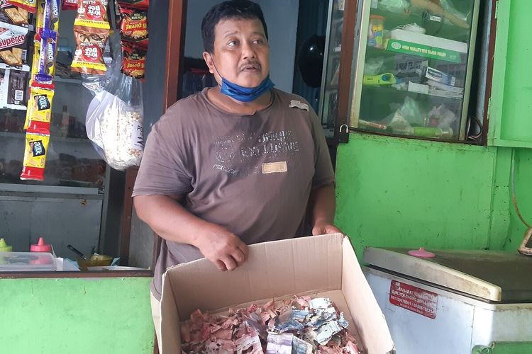 Samin (53) penjaga sekolah di Sekolah Dasar (SD) Negeri Lojiwetan No 49 Kecamatan Pasar Kliwon, Solo, Jawa Tengah, menunjukkan uang tabungan puluhan juta di celengan dimakan rayap, Selasa (13/9/2022).
