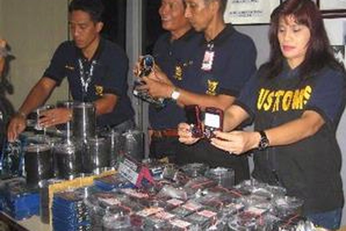 Beberapa petugas Kantor Pelayanan Bea dan Cukai Bandara Internasional Soekarno-Hatta, Selasa (2/12), memperlihatkan BlackBerry serta ribuan keping DVD dan DVD Blu-ray selundupan hasil sitaan.