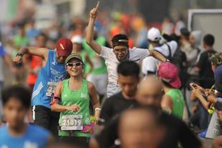 Ekspresi dan gaya peserta Mandiri Jakarta Marathon 2015 saat memasuki garis finis di Silang Monas Barat Daya, Jakarta, Minggu (25/10/2015).