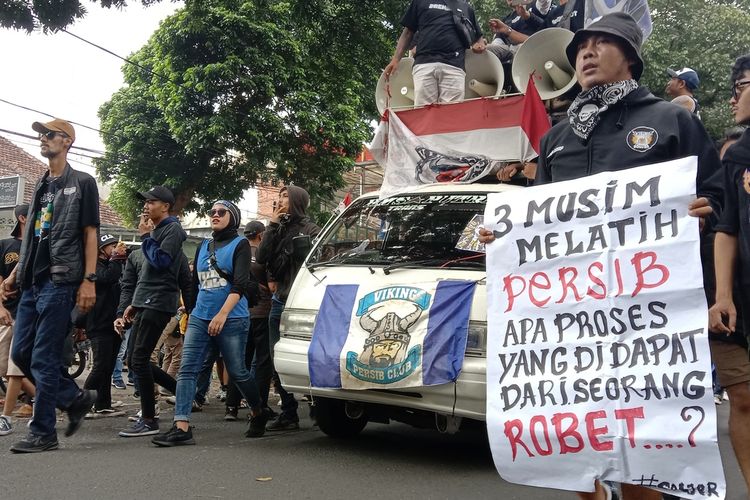 Fans Klub Sepak Bola Persib Bandung tengah melakukan aksi unjuk rasa di Graha Persib Bandung. Mereka meneriakan 'Rene out, ganti pelatih sekarang juga'.