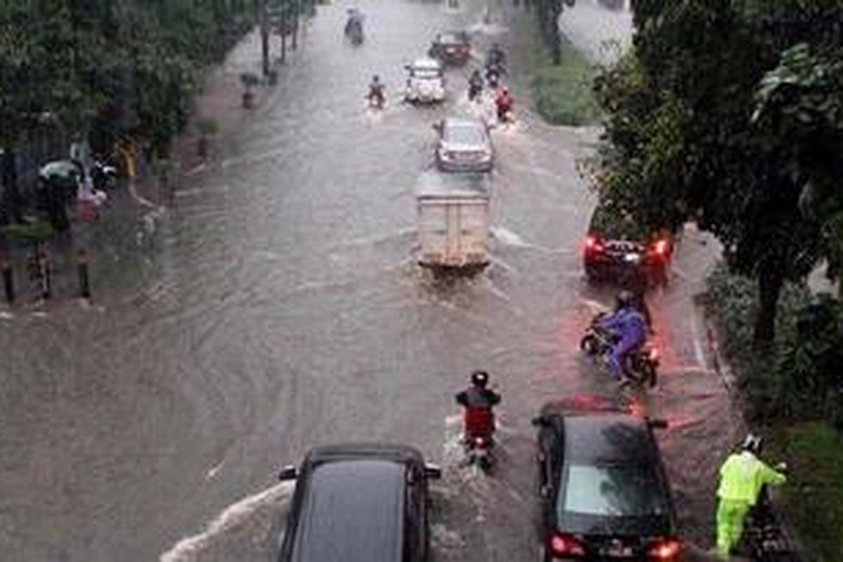Sejumlah kendaraan bermotor melintas sebagian ruas Jalan Jendral Sudirman yang tergenang air saat hujan deras yang mengguyur Jakarta, Senin (25/10/2010) sore. Akibat genangan air ini, arus lalu lintas di sebagian ruas jalan tersebut mengalami kemacetan.   