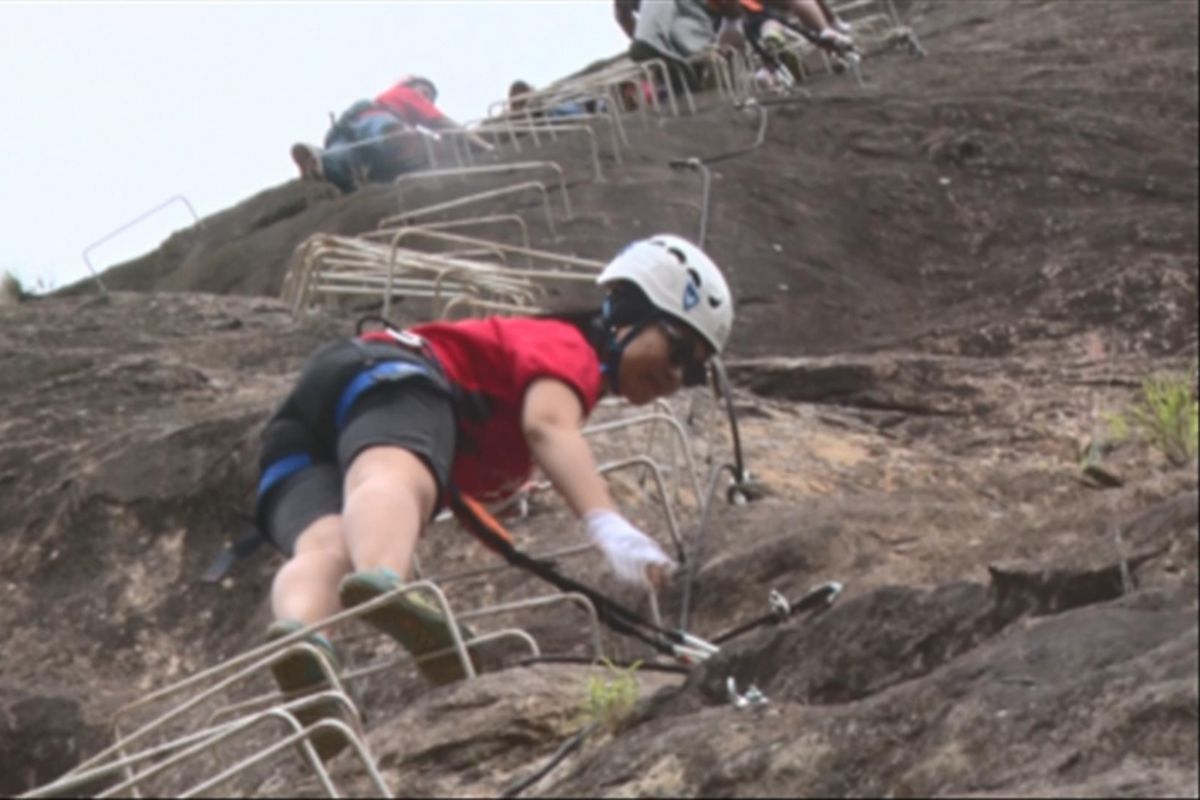 Wisatawan memanjat Via Ferrata di tebing Gunung Sepikul Desa Watuagung, Kecamatan Watulimo, Kabupaten Trenggalek, Jawa Timur, Minggu (1/10/2017).