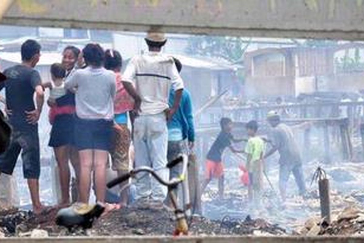 Warga mengamati bangunan rumahnya yang rata dengan tanah setelah terjadi kebakaran di  RT 10 RW 04, Kapuk Muara, Penjaringan, Jakarta Utara, Rabu (22/8/2012). Kebakaran yang melanda pemukiman padat penduduk tersebut di duga dari sebuah kompor pada pukul 09.30 WIB dan menghanguskan sebanyak 300 rumah semi permanen.