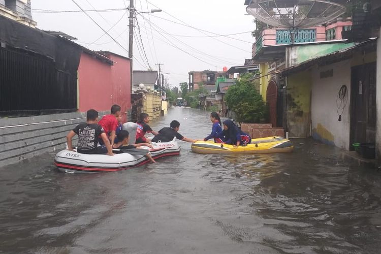 Petugas menggunakan perahu karet saat banjir permukiman warga di Pangkal Pinang, Minggu (5/5/2019).