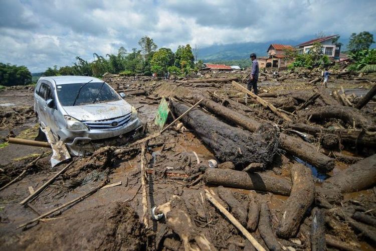 Warga melihat sebuah mobil yang terdampak banjir bandang di Nagari Bukik Batabuah, Agam, Sumatera Barat, Minggu (12/5/2024)