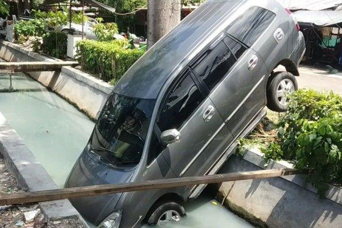 Satu unit mobil Toyota Kijang Innova terperosok ke dalam kali di Sunter Jaya, Minggu (12/1/2020) siang.