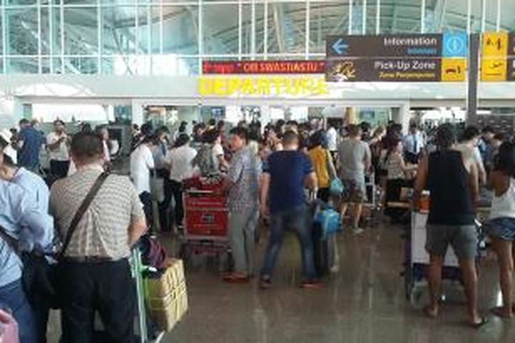 Calon penumpang sedang check in di terminal internasional Bandara Ngurah Rai. 
