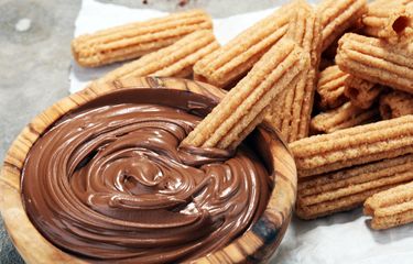 Sepiring Churros Saus Cokelat yang renyah, disajikan dengan saus cokelat kental di sampingnya