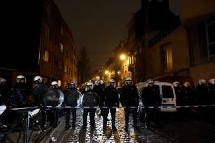 Polisi Belgia berjaga di salah satu sudut permukiman Molenbeek, Brussels, saat operasi penangkapan tersangka pelaku serangan Paris, Salah Abdeslam, Jumat (18/3/2016).