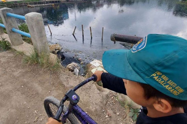 Warga beraktivitas di sekitar Situ Ciburuy, Kabupaten Bandung Barat yang berubah warna menjadi hitam pekat dan bau tak sedap setelah tercemar limbah, Kamis (14/7/2022).