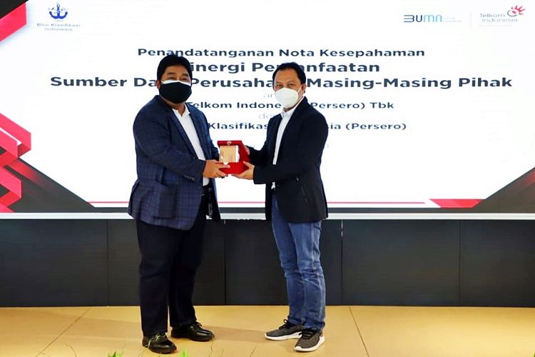 Direktur Enterprise dan Business Service Telkom Edi Witjara (kanan) menyerahkan cindera mata kepada Direktur Pengembangan Sumber Daya BKI Saifudin Wijaya usai penandatanganan Nota Kesepahaman tentang Sinergi Pemanfaatan Sumber Daya Perusahaan di Jakarta pada Rabu (24/3/2021).
