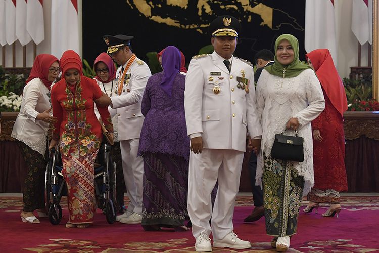 Gubernur Jawa Barat Ridwan Kamil (ketiga kiri) membantu istri duduk di kursi roda sebelum foto bersama dengan Wakil Gubernur Uu Ruzhanul Ulum beserta istri di Istana Negara, Jakarta, Rabu (5/9/2018). Presiden melantik sembilan gubernur dan wakil gubernur hasil Pilkada Serentak 2018, yaitu Papua, NTT, Jawa Tengah, Sumatera Utara, Bali, Jawa Barat, Kalimantan Barat, Sulawesi Selatan, dan Sulawesi Tenggara.