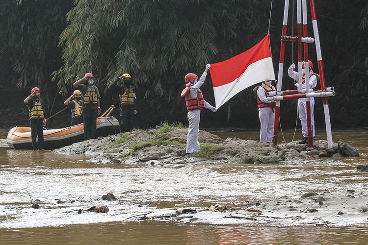 Peserta mengikuti upacara pengibaran bendera,  di Sungai Ciliwung, GDC, Depok, Jawa Barat, Senin (17/8/2020). Kegiatan yang diselenggarakan Komunitas Ciliwung Depok tersebut dalam rangka memperingati HUT ke-75 Kemerdekaan Republik Indonesia.