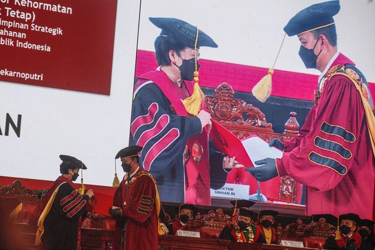 Presiden Indonesia ke-5 Prof. Dr. (H.C) Megawati Soekarnoputri (kiri) menerima piagam dari Rektor Universitas Pertahanan Laksamana Madya TNI Amarulla Octavian (kiri) saat prosesi  Pengukuhan Guru Besar  di Aula Merah Putih, Universitas Pertahanan, Sentul, Kabupaten Bogor, Jawa Barat, Jumat (11/6/2021). Megawati Soekarnoputri menerima gelar profesor kehormatan (guru besar tidak tetap) Ilmu Pertahanan Bidang Kepemimpinan Strategik pada Fakultas Strategi Pertahanan Universitas Pertahanan. ANTARA  FOTO/Yulius Satria Wijaya/hp.