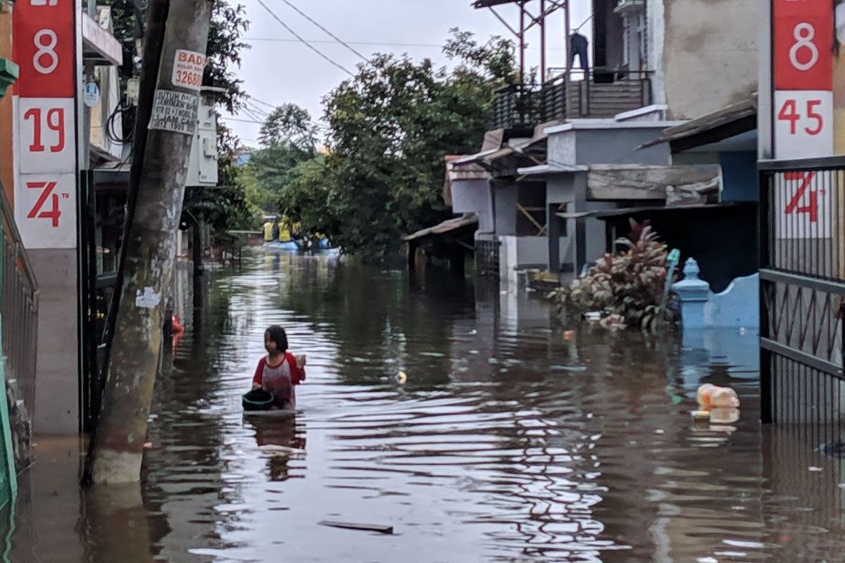 Seorang anak korban banjir mencari ikan di perumahan RW 08 Periuk Indah Kota Tangerang, Kamis (6/2/2020)