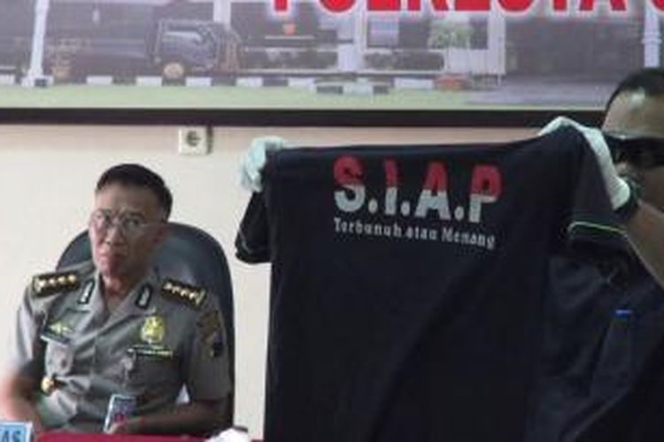 Petugas tunjukan kaos yang disita dari tersangka teroris di Solo, Jumat (14/8/2015).