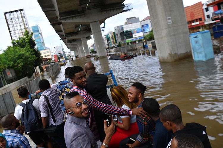 Sejumlah warga negara asing menumpang di atas sebuah truk saat banjir menggenangi Jalan Boulevard Barat Raya, Kelapa Gading, Jakarta Utara, Minggu (23/2/2020). Hujan deras sejak Minggu 23 Februari dini hari membuat sejumlah daerah di Ibu Kota tergenang banjir.