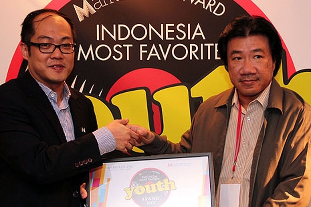 A Indraputra menerima penghargaan Indonesia Most Favorite Youth Brands 2012 dari Chief Operating Officer Markplus, Michael Hermawan.