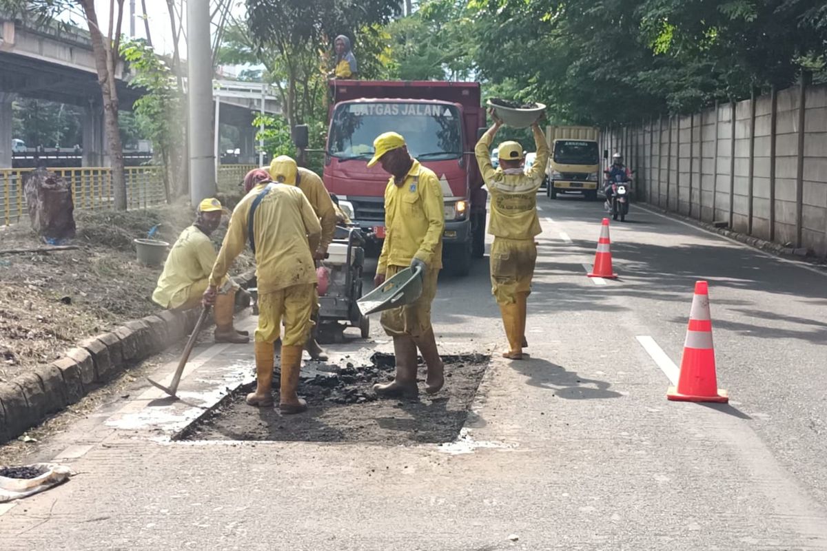 Petugas memperbaiki jalan inspeksi Ancol yang akan digunakan untuk event memfasilitasi para pebalap liar di Jakarta Utara, Selasa (11/1/2022).