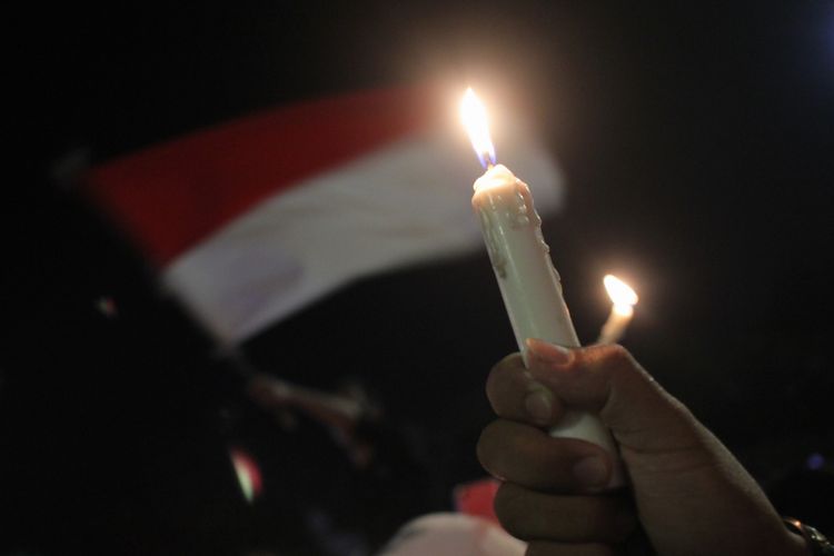 Warga menyalakan lilin saat aksi lilin kebersamaan Suroboyo Wani di Tugu Pahlawan, Surabaya, Jawa Timur, Minggu (13/5). Aksi yang diikuti ratusan orang dari berbagai lapisan itu mengecam aksi terorisme bom bunuh diri yang terjadi di Surabaya. ANTARA FOTO/Didik Suhartono/ama/18