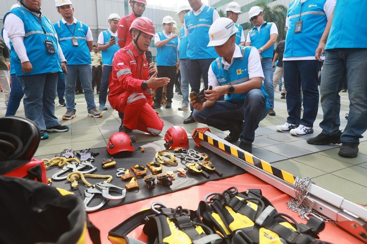 Pada Apel Bulan Keselamatan dan Kesehatan Kerja (K3) Nasional 2025, Jumat (10/01), Direktur Utama PLN, Darmawan Prasodjo (kanan) melakukan pengecekan terhadap peralatan yang digunakan oleh petugas PLN untuk memastikan kesesuaian dengan standar K3.