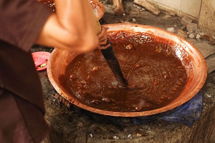 A number of workers knead the dodol and basket cake dough at the Dodol and Ny Cake production house. Lauw (LKW), in Tangerang, Banten, Friday (17/1/2025). The production process uses a traditional furnace.