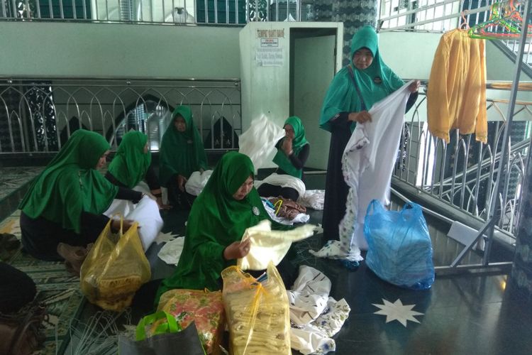 Ibu-ibu dari Gerakan Mukena Bersih sedang menata mukena di Masjid Baiturrahman, Banyuwangi, Kamis (24/5/2018).