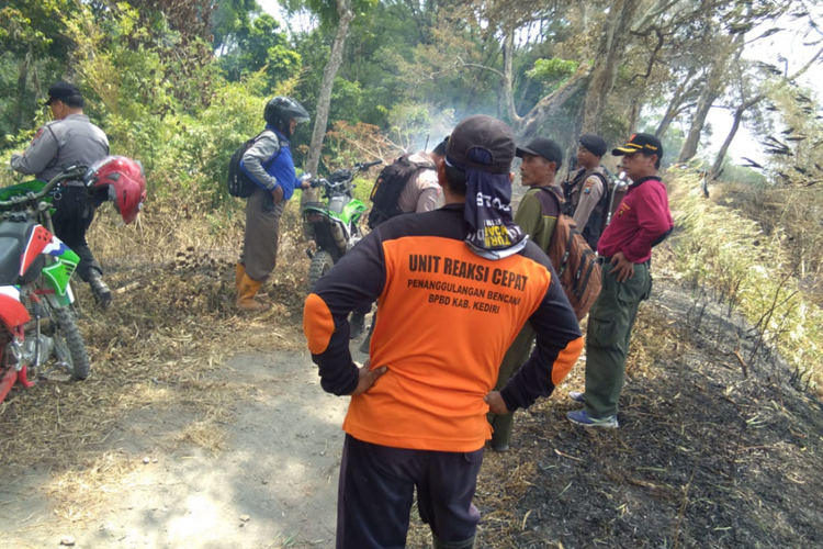 Petugas gabungan mengatasi kebakaran hutan lindung di Bukit Ongakan Kediri, Jawa Timur, Jumat (28/9/2018).