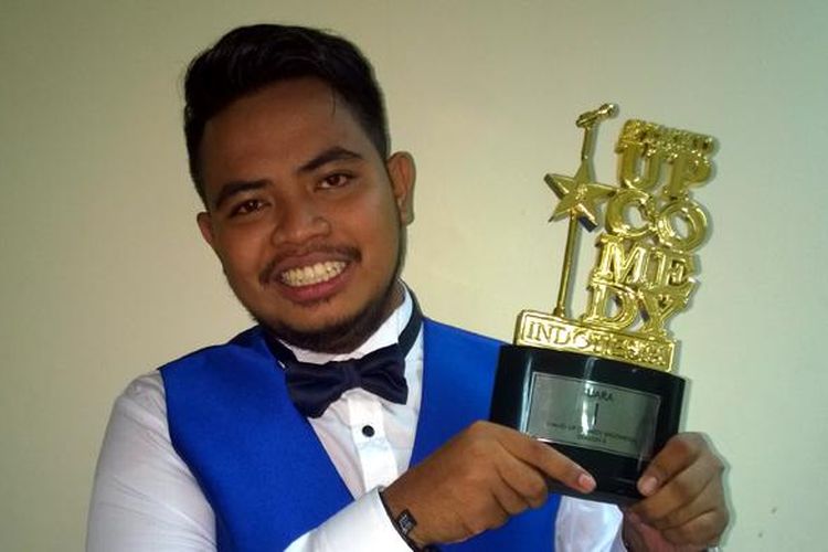 Komika asal Bima, NTB, Rigen, berpose mengangkat piala setelah berhasil menjadi juara 1 kompetisi Stand Up Comedy Indonesia Season 5 (SUCI 5) yang ditayangkan Kompas TV. Rigen berhasil menjadi juara setelah menyisihkan Rahmet dan Indra di babak Grand Final SUCI 5 di Balai Kartini, Jakarta, Jumat (3/7/2015).