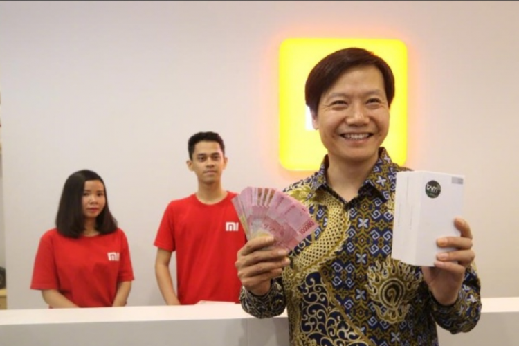 CEO Xiaomi, Lei Jun, memamerkan duit rupiah dan dua boks Redmi Note 4X.