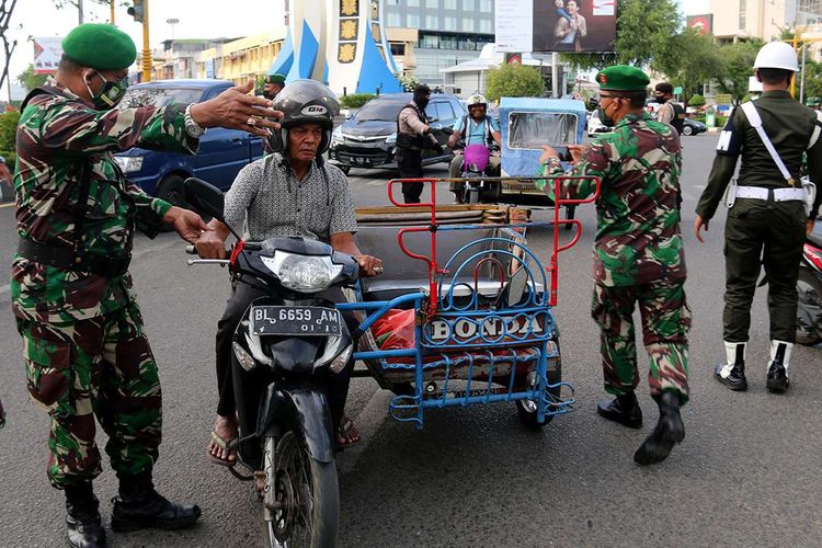 Petugas gabungan dari TNI, Polisi dan Satpol PP-WH melakukan razia masker di Bundaran Simpang Lima, Pusat Kota Banda Aceh, Kamis (25/6/2020). Razia masker ini ditingkatkan untuk menekan angka paparan Covid-19 di Aceh yang semakin meningkat dalam sepekan terakhir, dengan kenaikan jumlah pasien positif Covid-19 menjadi 66 orang, satu di antaranya warga negara asing (WNA).