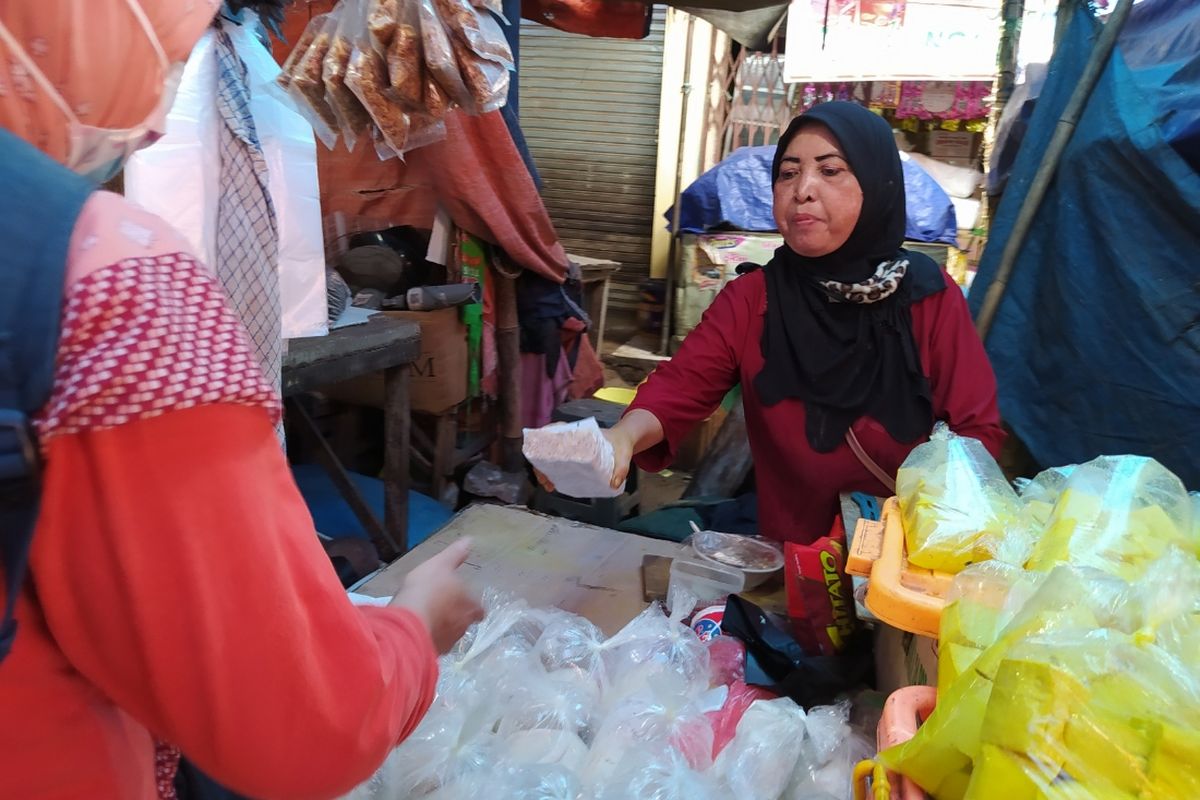 Salah satu penjual tahu dan tempe di Pasar Anyar Tangerang sedang menjual tempe ke salah satu pembelinya, Senin (4/1/2021) siang.