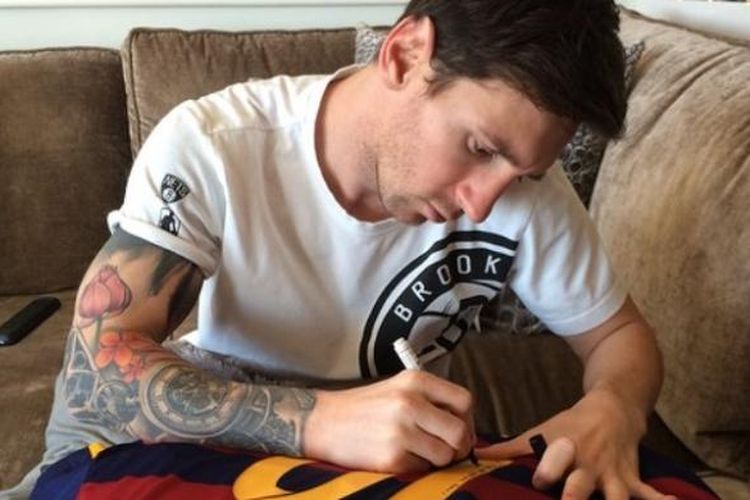 Lionel Messi menandatangani seragam Barcelona bernomor 10 untuk diberikan kepada Ronaldinho.