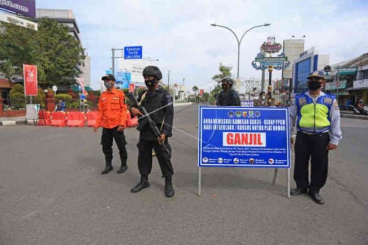 Petugas gabungan berjaga saat uji coba ganjil genap di jalan RA Kartini, Kota Cirebon, Jawa Barat, Jumat (13/8/2021). 