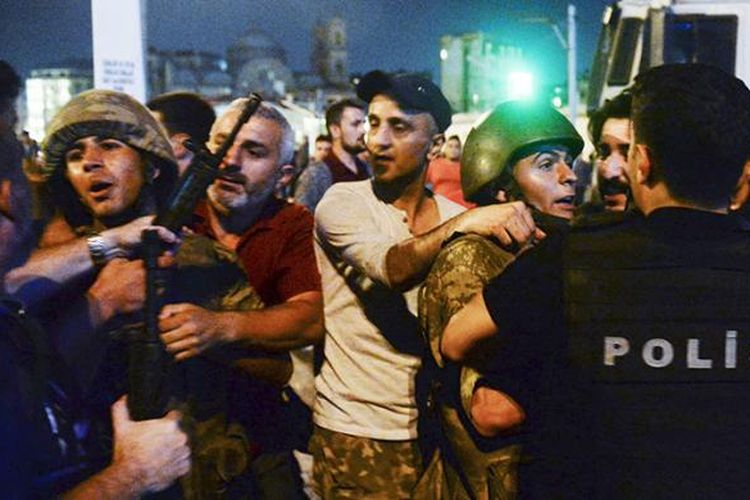 Tentara Turki yang ditangkap oleh warga sipil diserahkan ke polisi, di Taksim Square, Istanbul, Sabtu (16/7/2016) dini hari waktu setempat. Upaya kudeta terjadi pada Jumat malam setelah militer mengeluarkan pernyataan telah mengambil alih kekuasaan untuk mengembalikan aturan dan demokrasi di negeri itu.