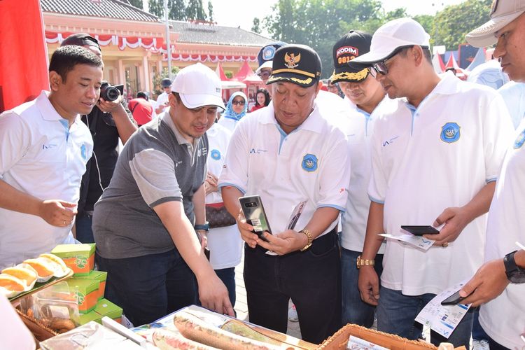 Bupati Lamongan, Fadeli (tengah) saat mencoba applikasi LA Pay di salah satu stan yang disediakan.