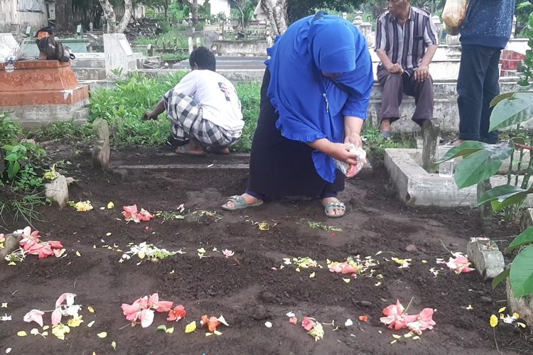 Warga menaburkan bunga diatas makam keluarganya, Kamis (7/3/2024)